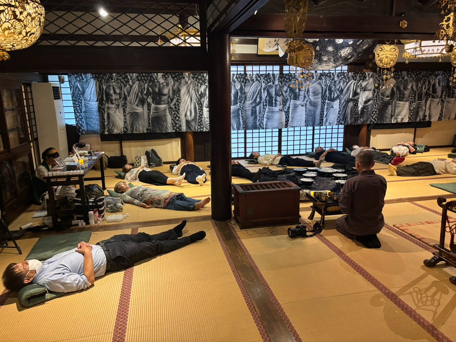 寺院の和室で体操や瞑想に取り組む参加者